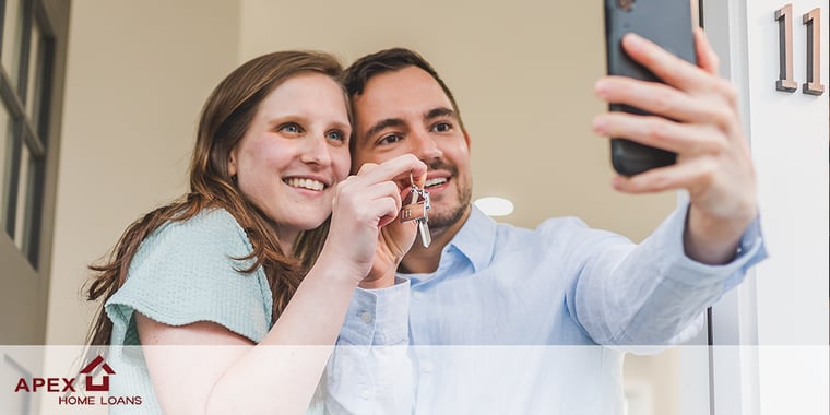 Couple taking selfie with keys to home